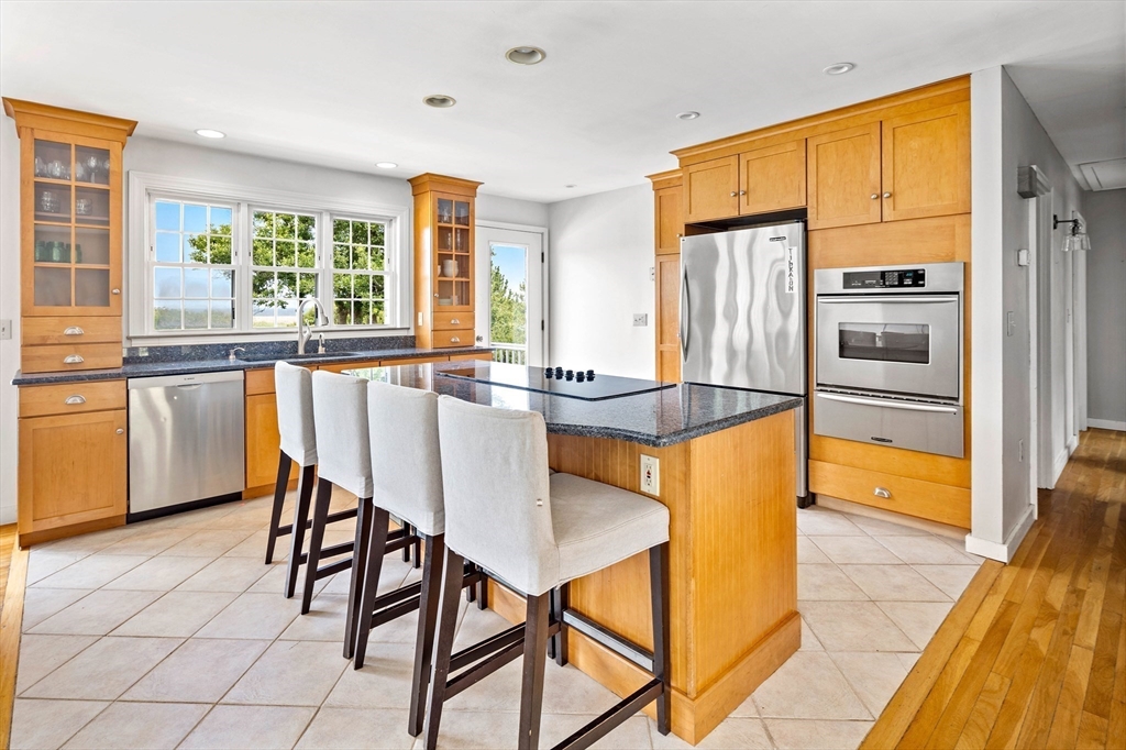 324 Hatherly Road Scituate, MA 02066 - Photo 4 of 15 a kitchen with stainless steel appliances granite countertop a stove top oven a sink a dining table and chairs