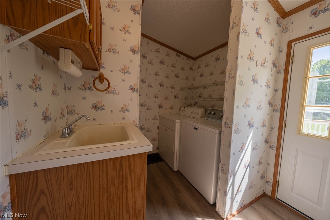 5000 Hoffman Road Rome, OH 44085 - Photo 29 of 34 Laundry area featuring washer and clothes dryer, ornamental molding, and light hardwood floors
