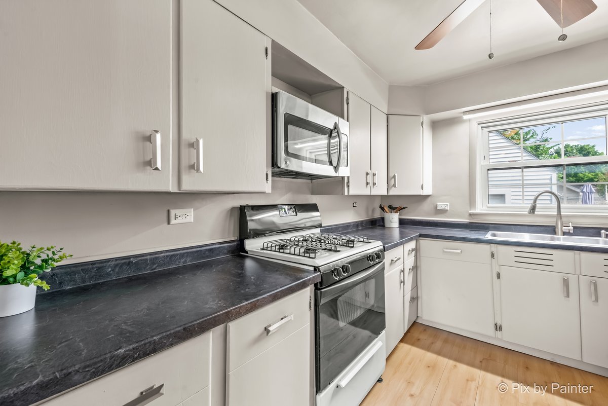 656 Ford Avenue Elgin, IL 60120 - Photo 6 of 18 a kitchen with stainless steel appliances granite countertop a sink a stove and a microwave