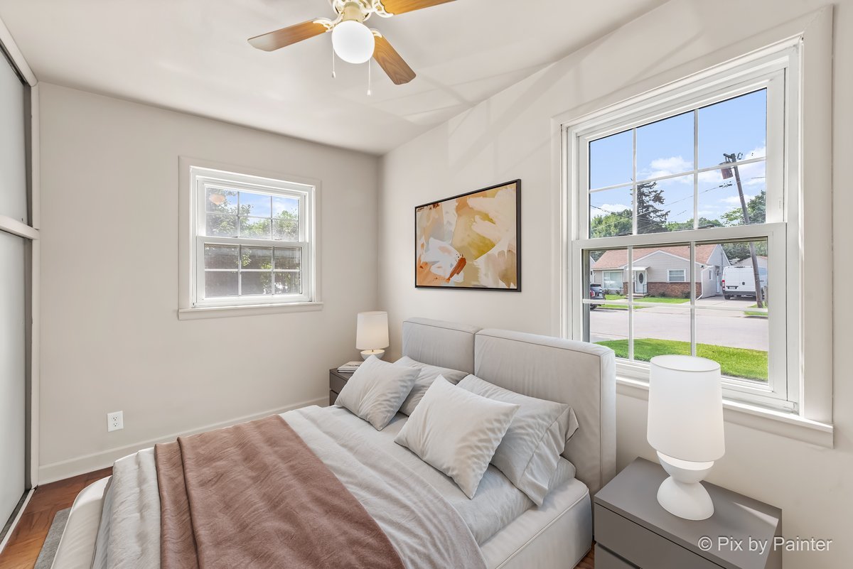 656 Ford Avenue Elgin, IL 60120 - Photo 10 of 18 a bedroom with a bed a bookshelf and a painting on the wall