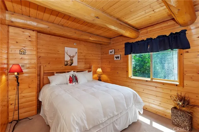 a bedroom with a bed a dresser and a window