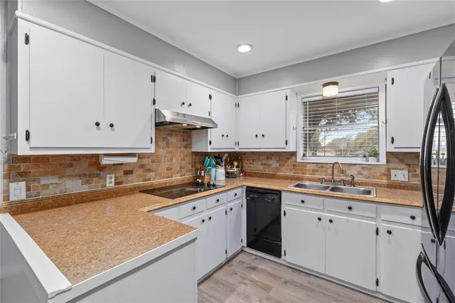 a kitchen with granite countertop a sink stove and cabinets