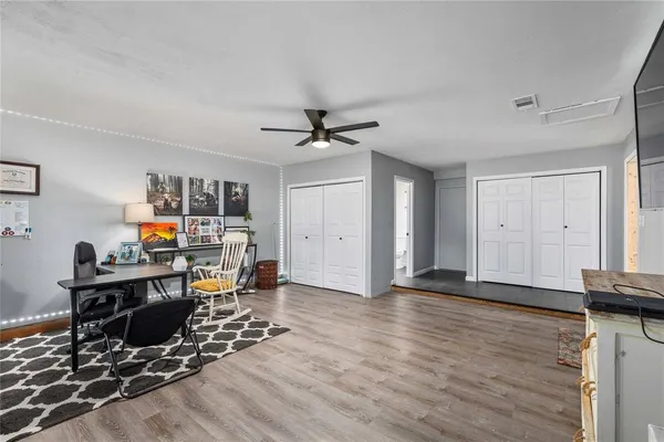 a living room with furniture and a wooden floor