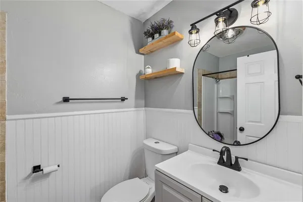a bathroom with a sink mirror and toilet