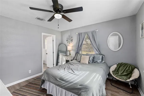 a bedroom with a bed a chandelier and a window