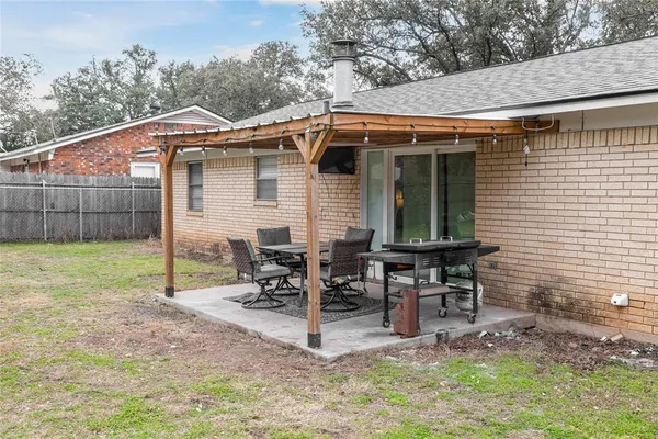 a backyard of a house with table and chairs