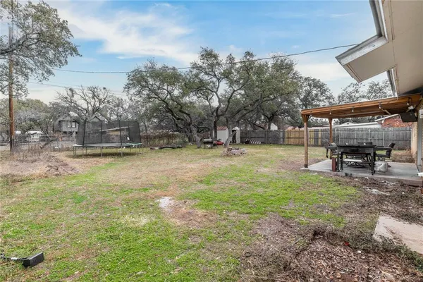 a view of a backyard with table and chairs under an umbrella
