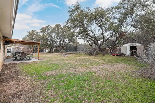 a view of a house with backyard and trees