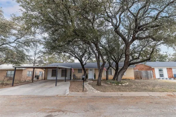 a front view of a house with a tree