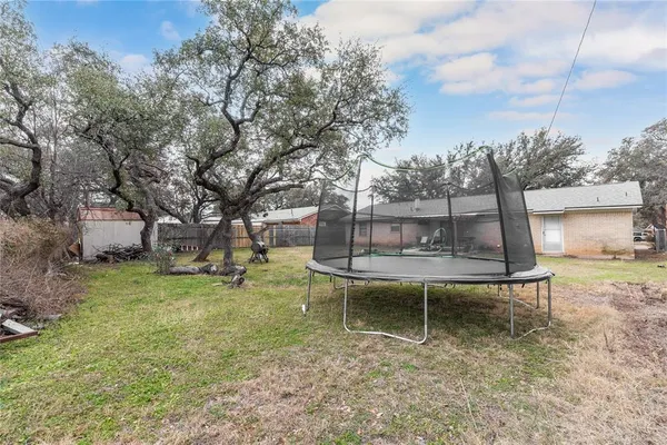 a view of a garden with a bench and fire pit
