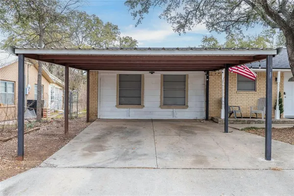 a backyard of a house with basket ball table and chairs