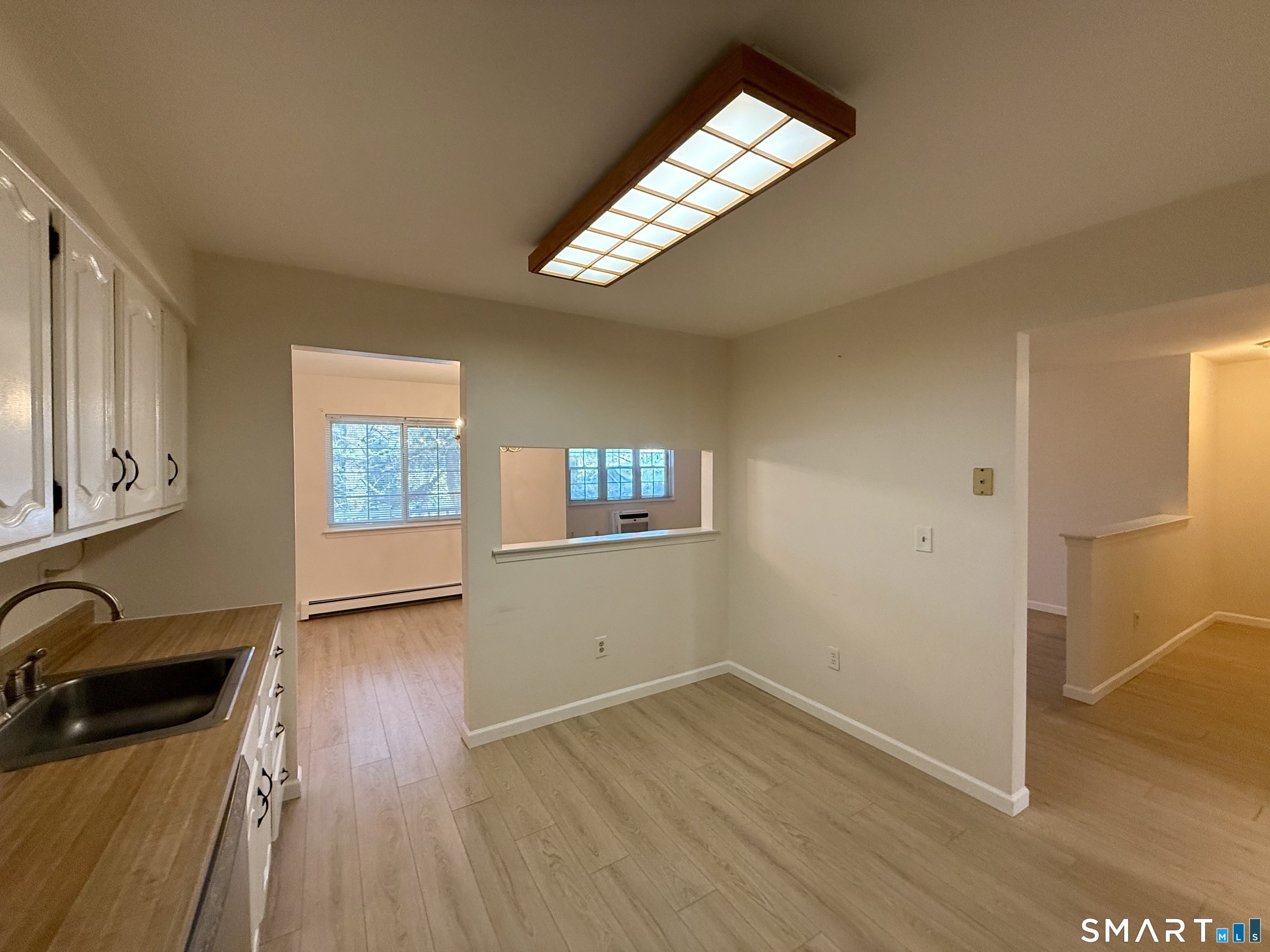 2955 Madison Avenue, Unit 4 Bridgeport, CT 06606 - Photo 7 of 15 an empty room with wooden floor fan and windows