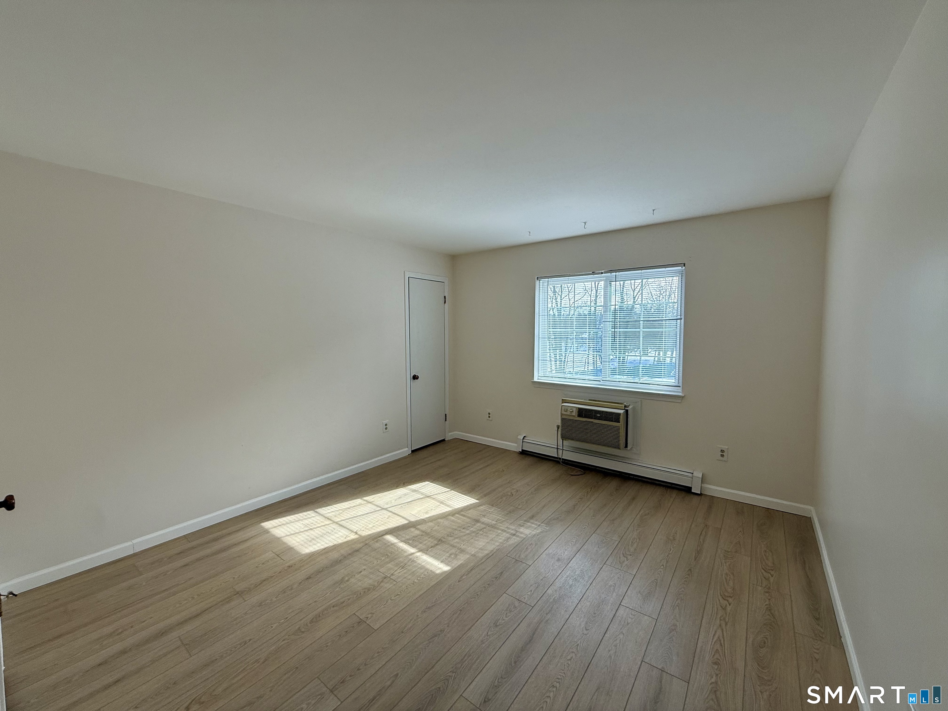 2955 Madison Avenue, Unit 4 Bridgeport, CT 06606 - Photo 8 of 15 an empty room with wooden floor and windows