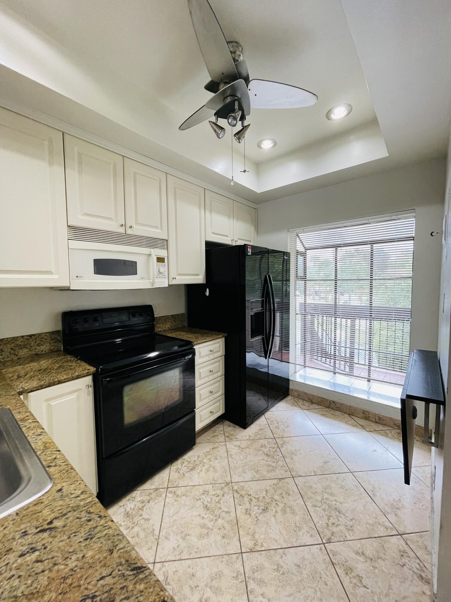 2297 Southwest 15th Street, Unit 122 Deerfield Beach, FL 33442 - Photo 11 of 47 a kitchen with granite countertop a stove cabinets and stainless steel appliances