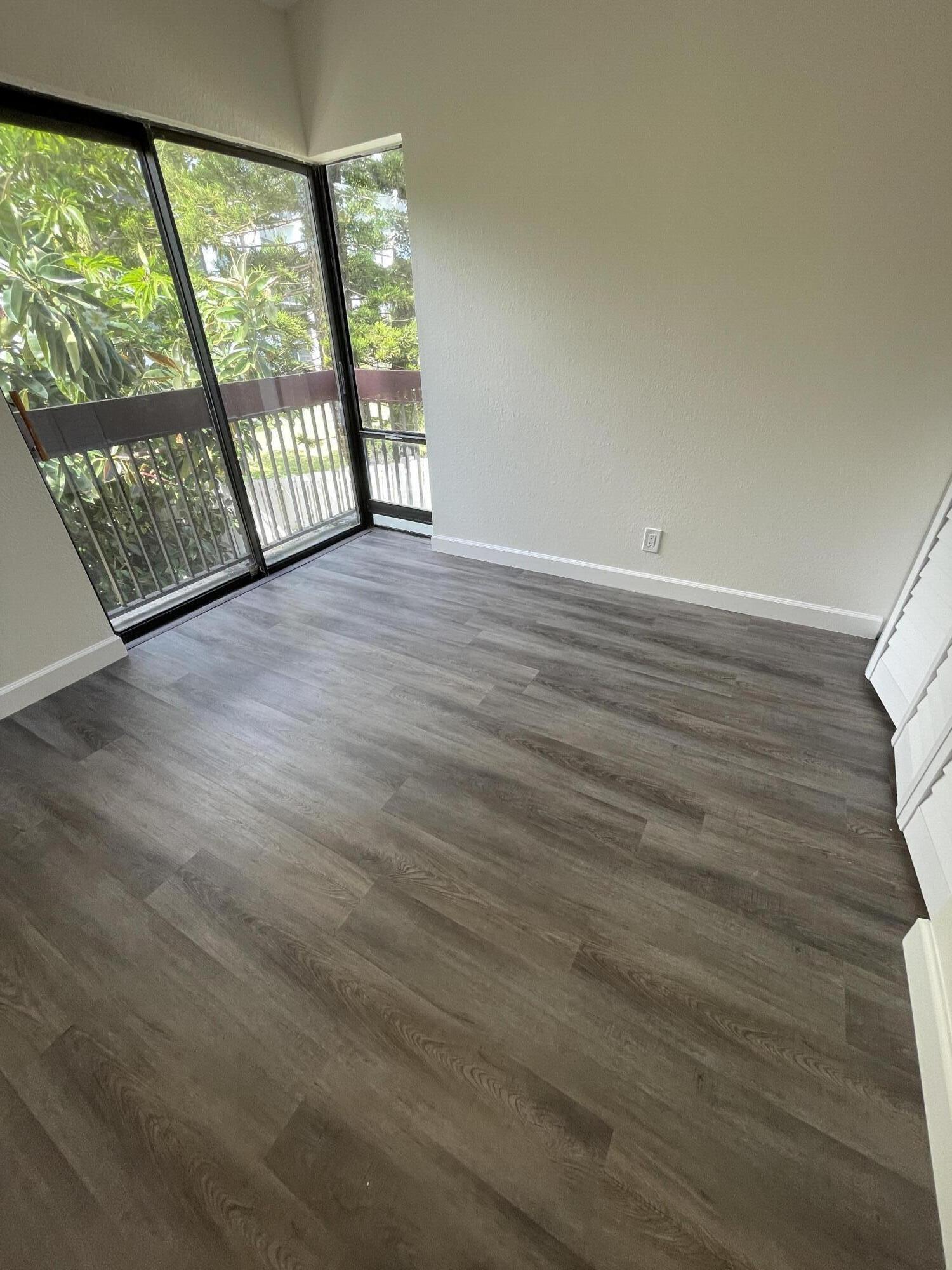 2297 Southwest 15th Street, Unit 122 Deerfield Beach, FL 33442 - Photo 14 of 47 an empty room with wooden floor and windows