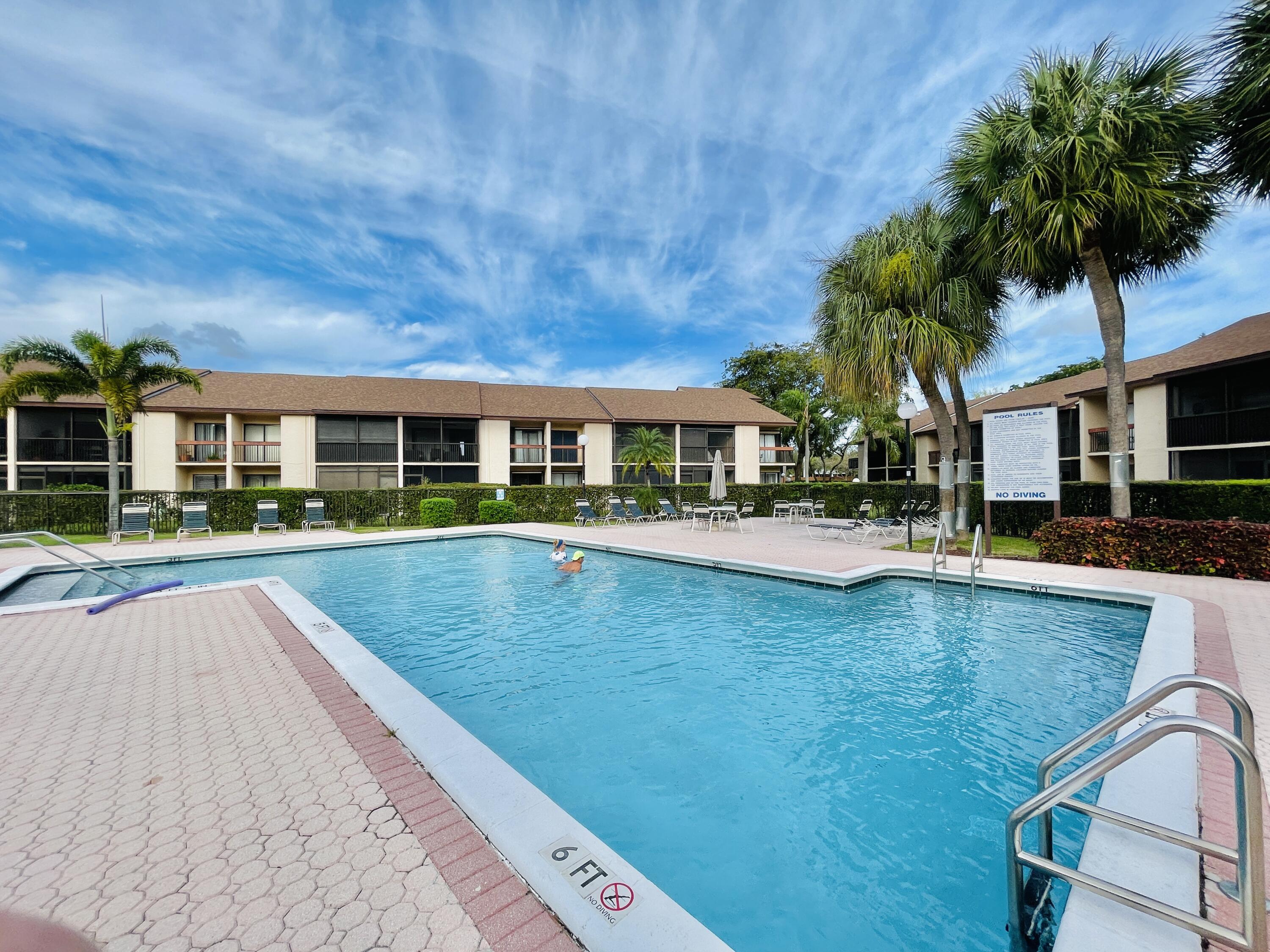 2297 Southwest 15th Street, Unit 122 Deerfield Beach, FL 33442 - Photo 29 of 47 a swimming pool view with a seating space and a garden view