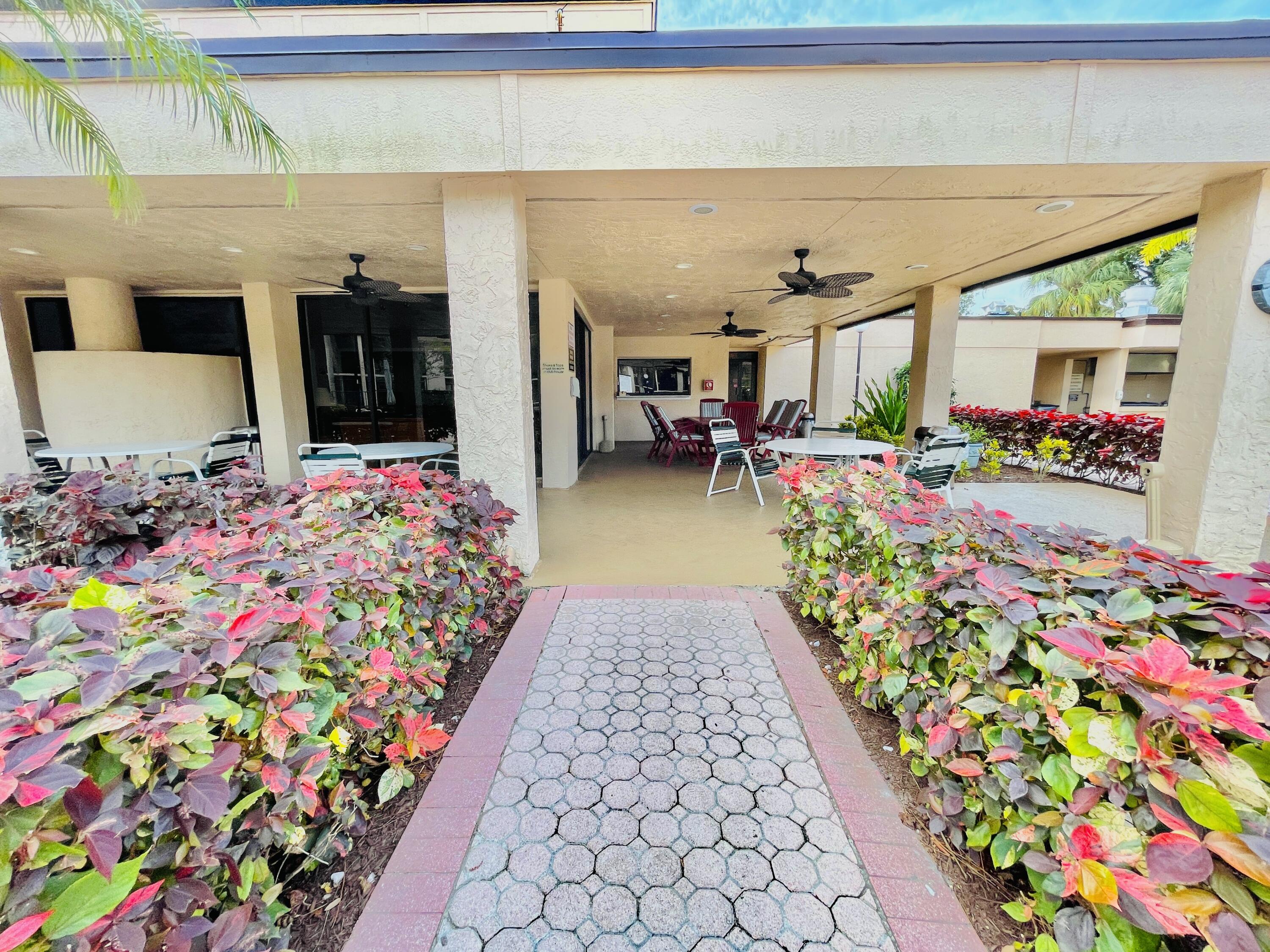 2297 Southwest 15th Street, Unit 122 Deerfield Beach, FL 33442 - Photo 34 of 47 a front view of a house with a porch and furniture
