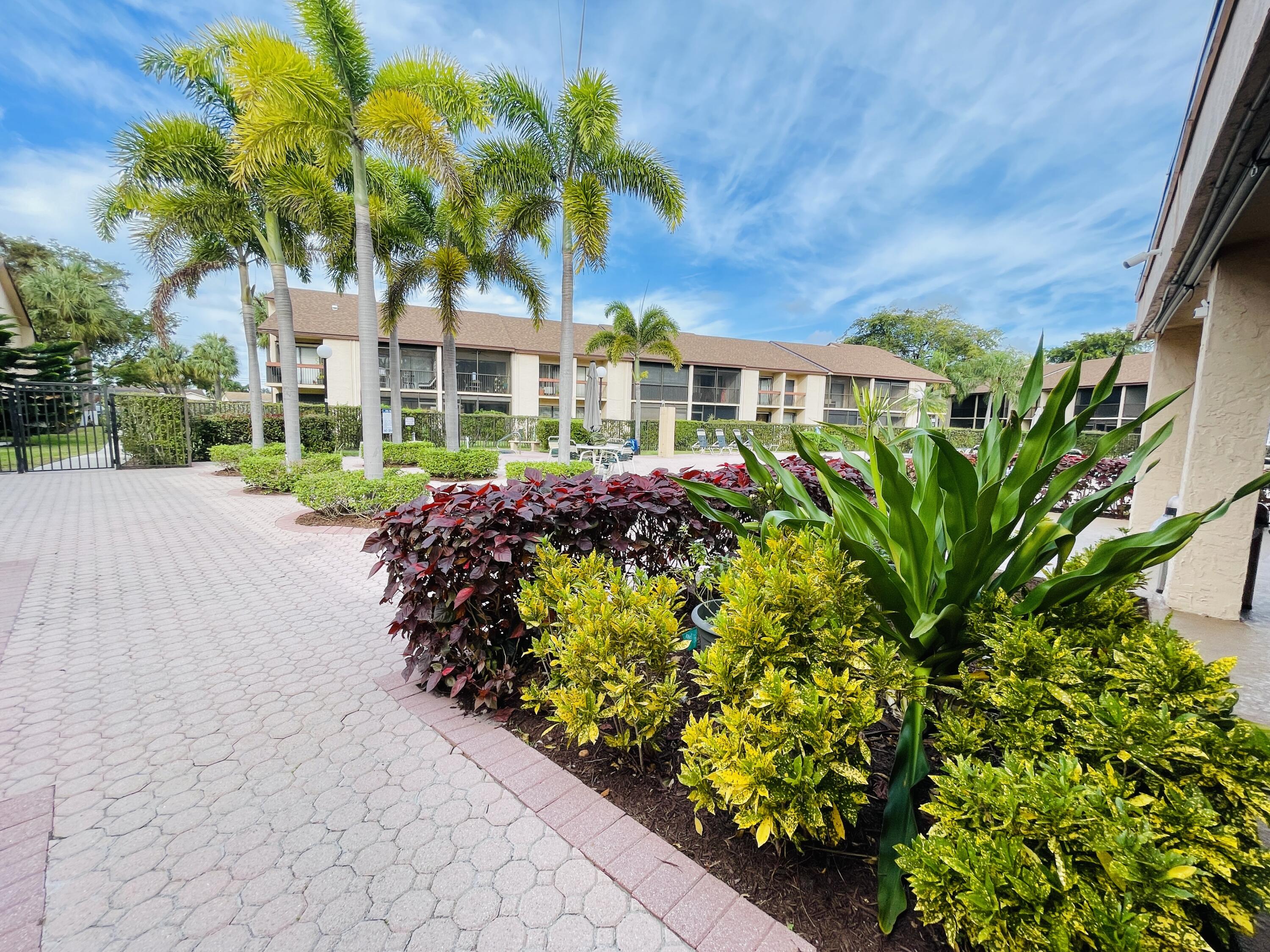 2297 Southwest 15th Street, Unit 122 Deerfield Beach, FL 33442 - Photo 38 of 47 a front view of a house with a garden