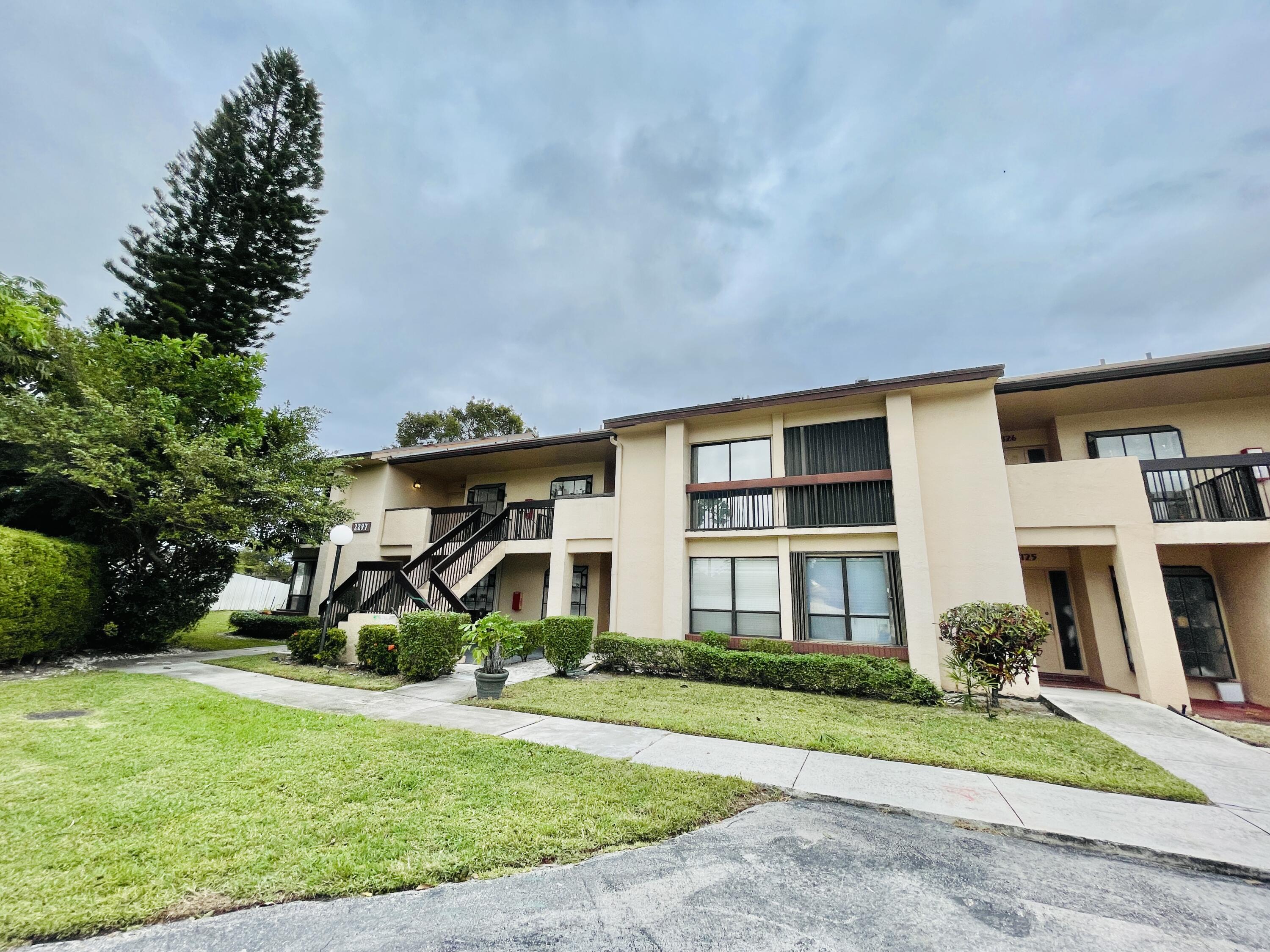 2297 Southwest 15th Street, Unit 122 Deerfield Beach, FL 33442 - Photo 4 of 47 a front view of a house with garden
