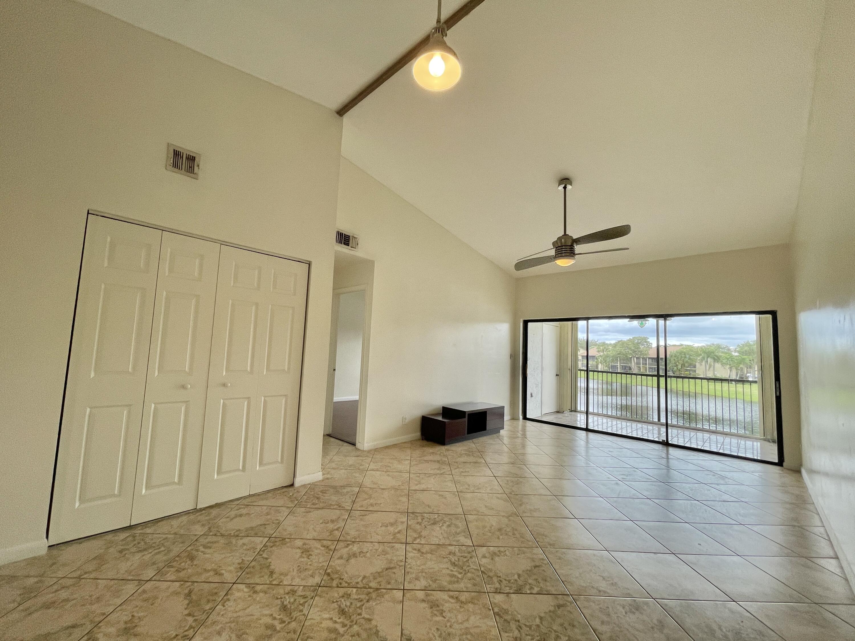 2297 Southwest 15th Street, Unit 122 Deerfield Beach, FL 33442 - Photo 5 of 47 a view of empty room with wooden floor and fan