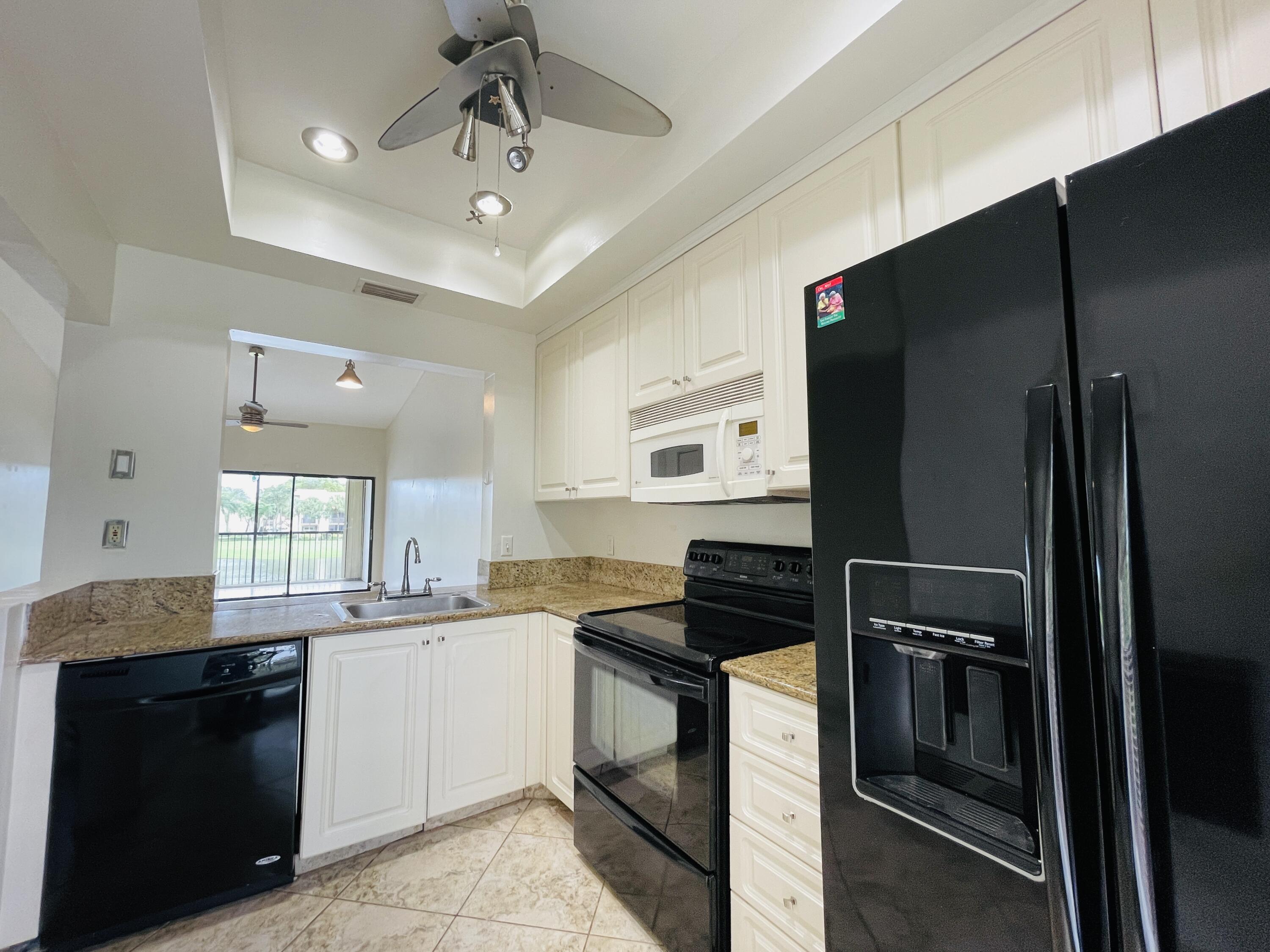 2297 Southwest 15th Street, Unit 122 Deerfield Beach, FL 33442 - Photo 8 of 47 a kitchen with a sink stainless steel appliances and cabinets