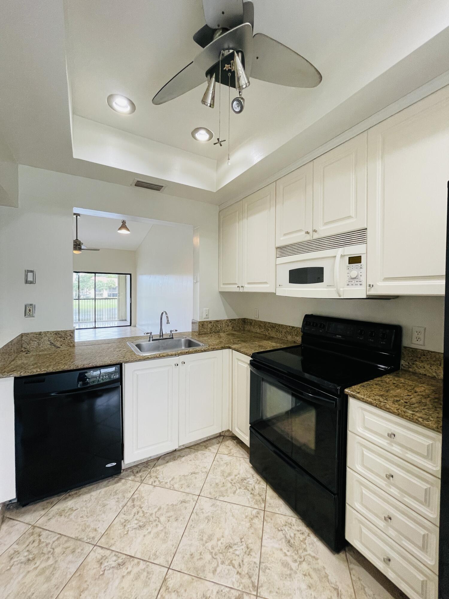 2297 Southwest 15th Street, Unit 122 Deerfield Beach, FL 33442 - Photo 9 of 47 a kitchen with a sink cabinets and stainless steel appliances