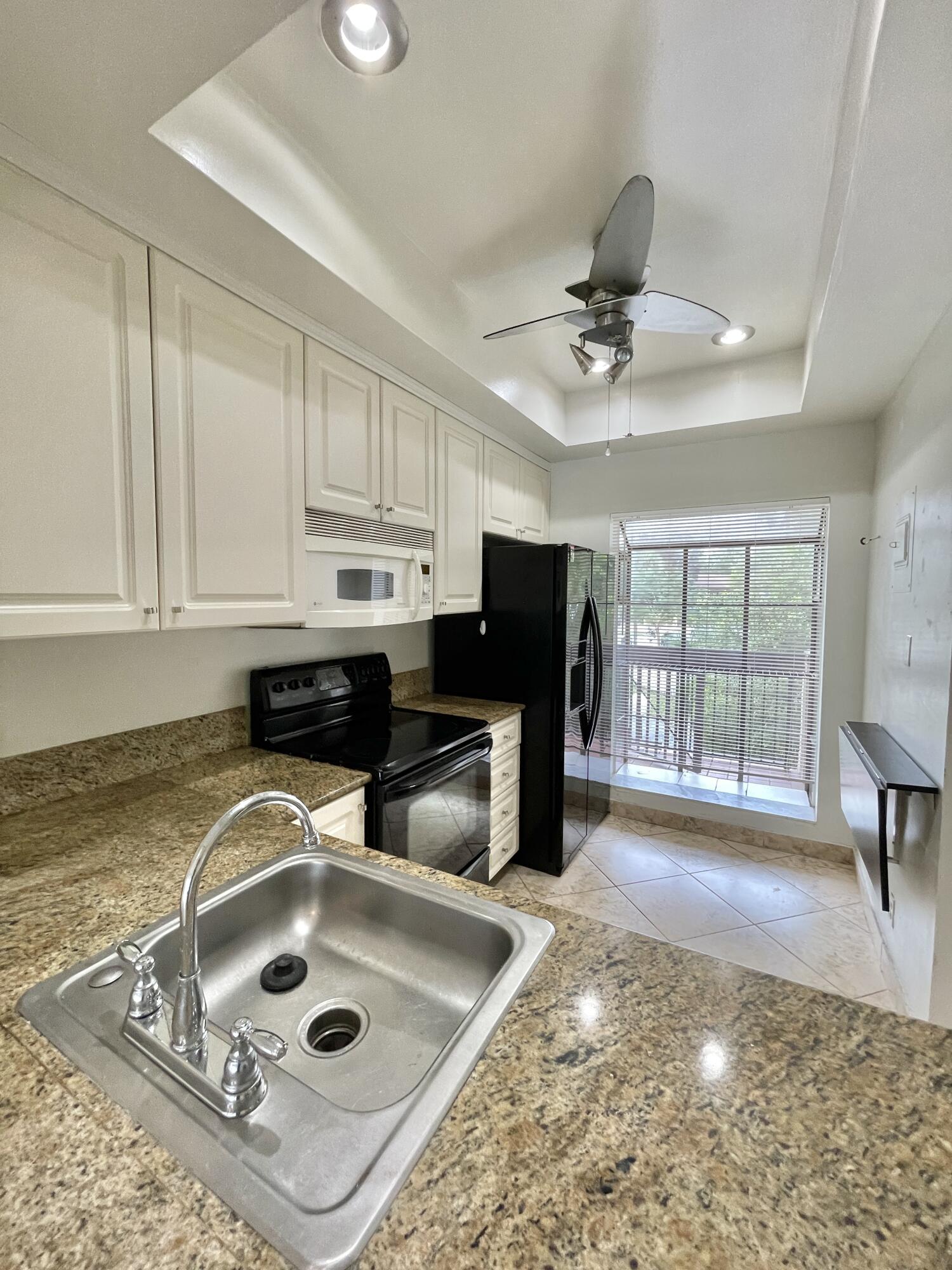 2297 Southwest 15th Street, Unit 122 Deerfield Beach, FL 33442 - Photo 10 of 47 a kitchen with stainless steel appliances granite countertop a sink stove and cabinets