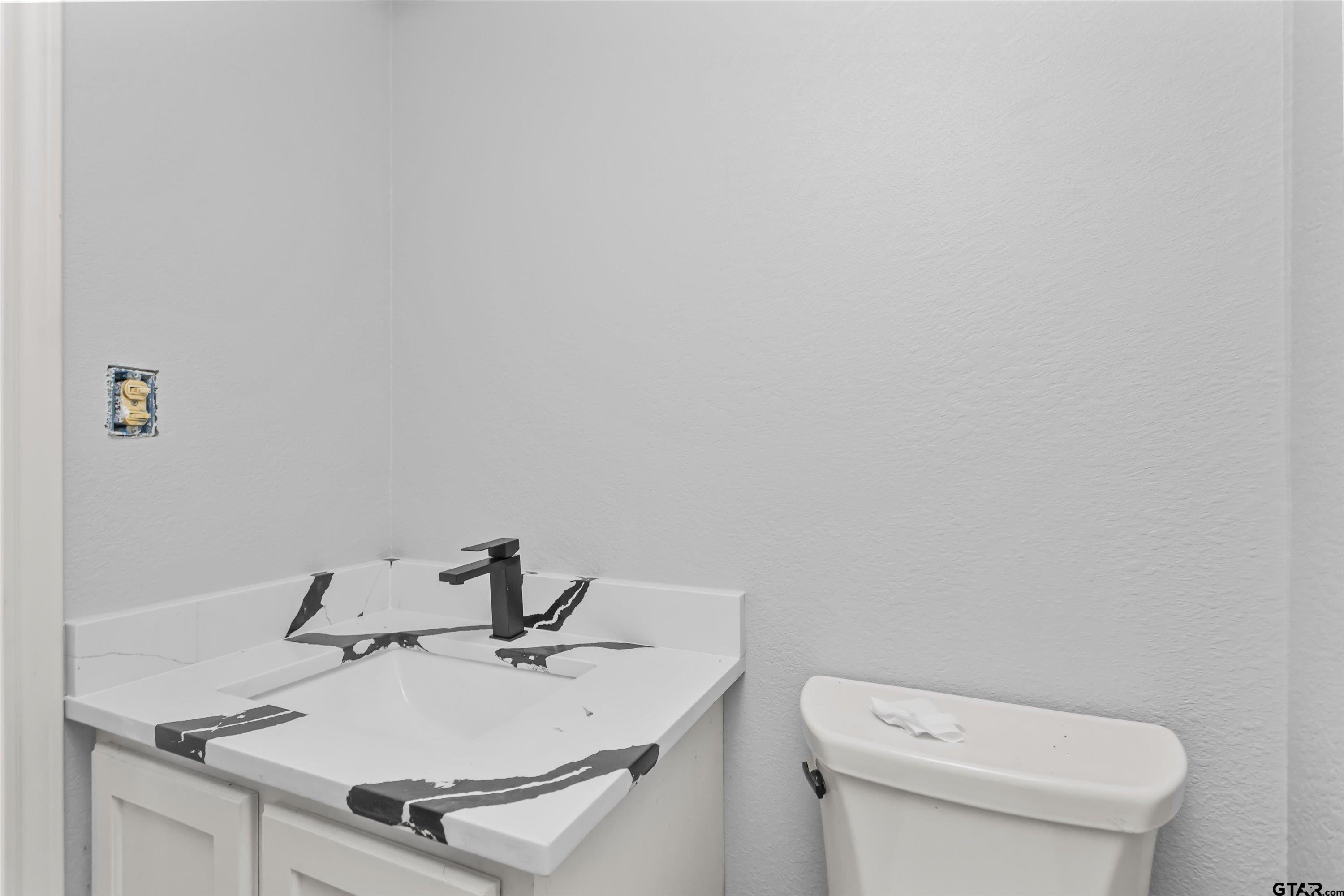 9374 Cedarvale Drive Tyler, TX 75708 - Photo 12 of 20 a white bathroom with a sink and a toilet