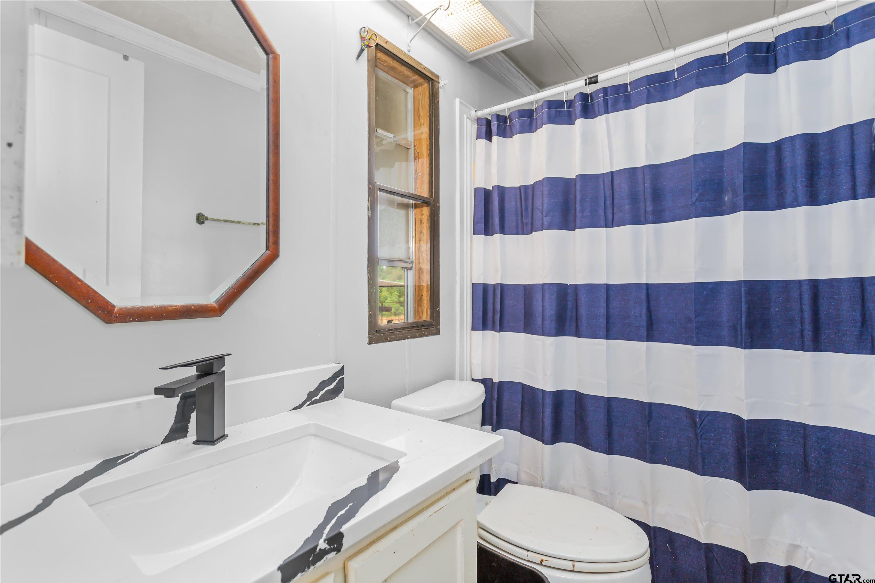 9374 Cedarvale Drive Tyler, TX 75708 - Photo 15 of 20 a bathroom with a sink and a mirror
