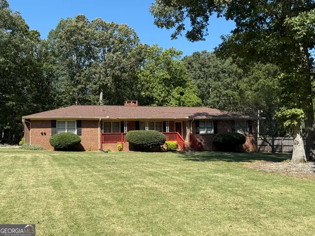 a view of a house with a yard and sitting area