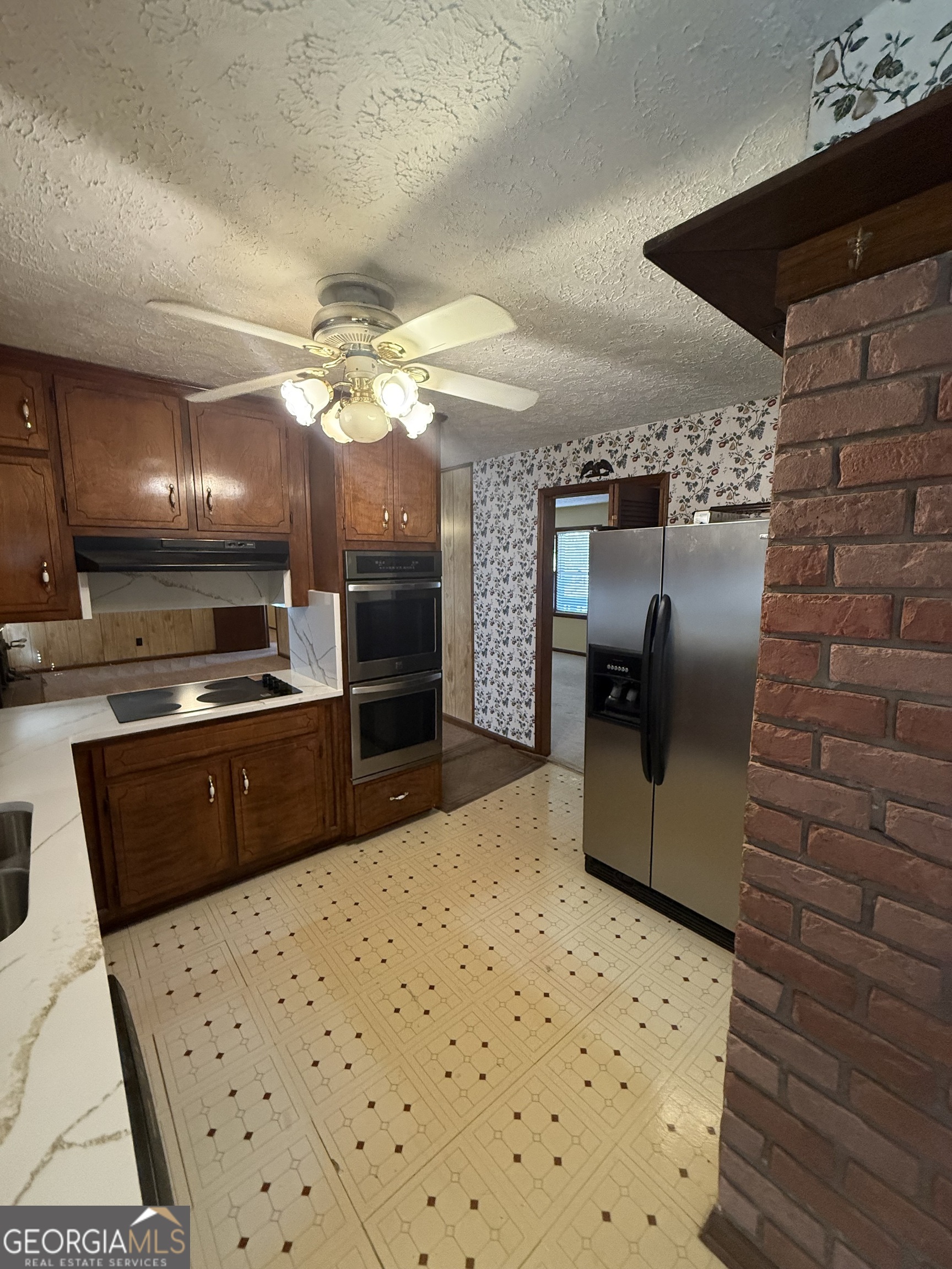 110 Otelia Lane Covington, GA 30014 - Photo 18 of 30 a kitchen with stainless steel appliances kitchen island granite countertop a refrigerator a stove and a sink with wooden floor