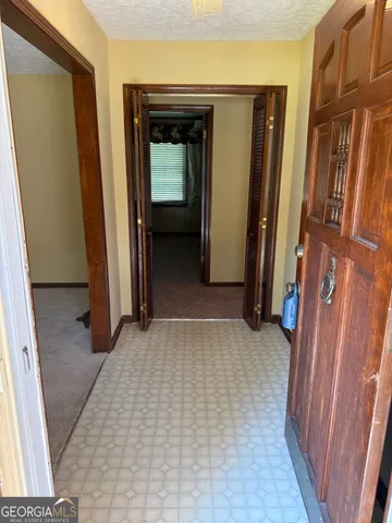a view of a hallway with wooden walls and stairs