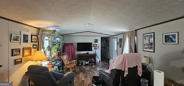 a living room with furniture a flat screen tv and a window