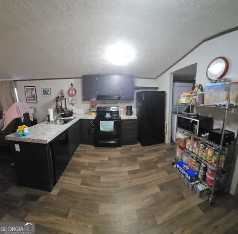 a kitchen with stainless steel appliances kitchen island granite countertop a sink dishwasher stove and refrigerator