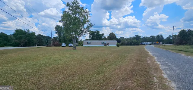 a view of a field with trees in background