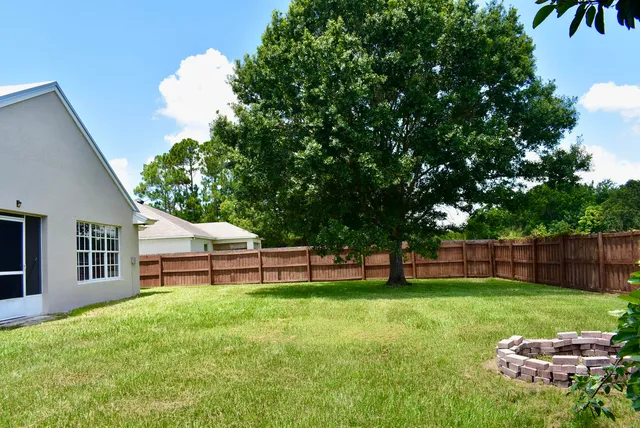 a view of a chair and table in backyard of the house