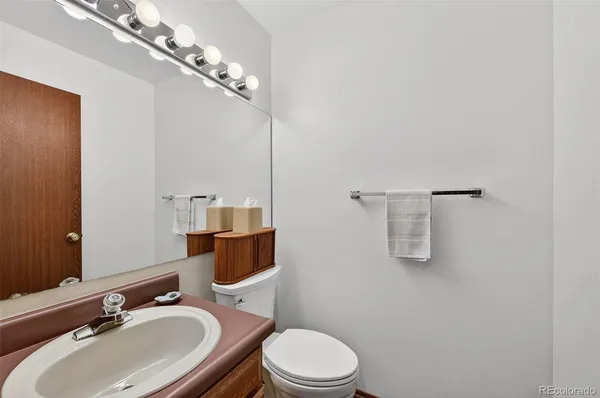 a bathroom with a toilet a sink and mirror