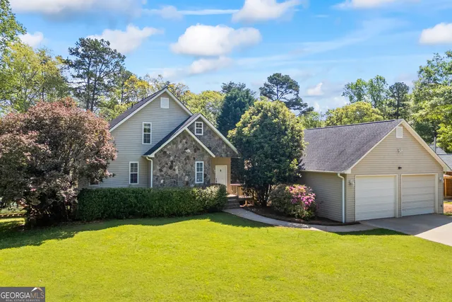 a front view of a house with a yard and trees