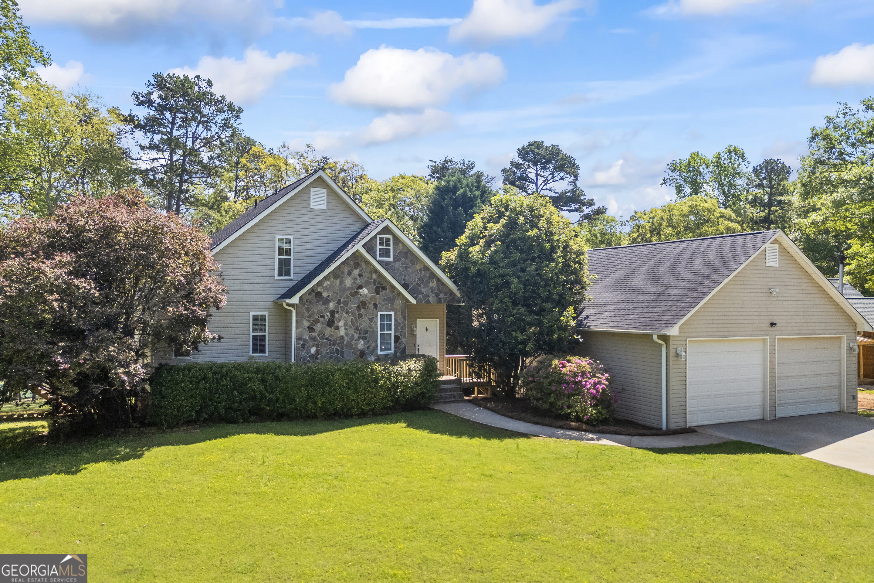 a front view of a house with a yard and trees