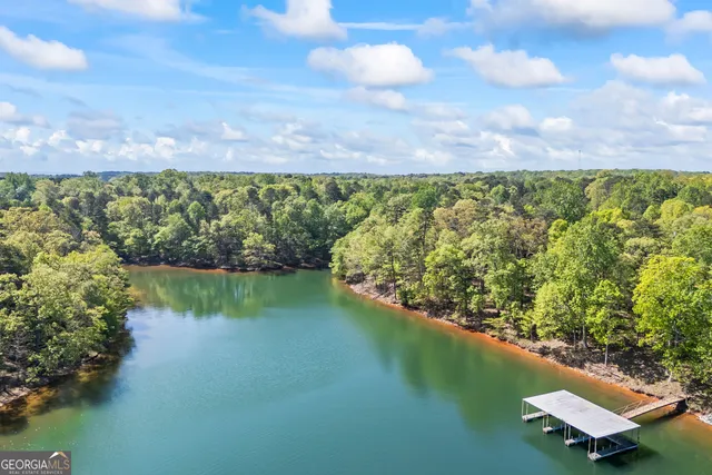 a view of a livingroom with wooden floor a ceiling fan and windows