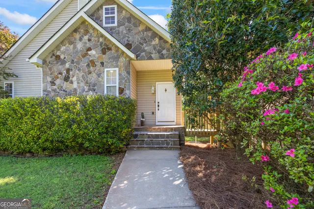 a view of an empty room with wooden floor fireplace and a window