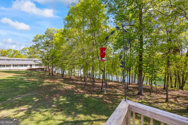 a kitchen with stainless steel appliances granite countertop a stove a sink dishwasher a refrigerator with white cabinets and wooden floor