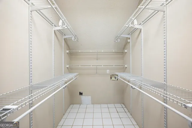 an empty room with windows and chandelier fan
