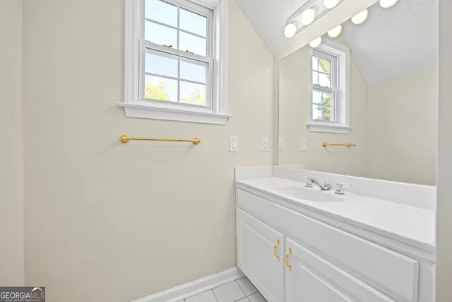 an empty room with chandelier fan and windows