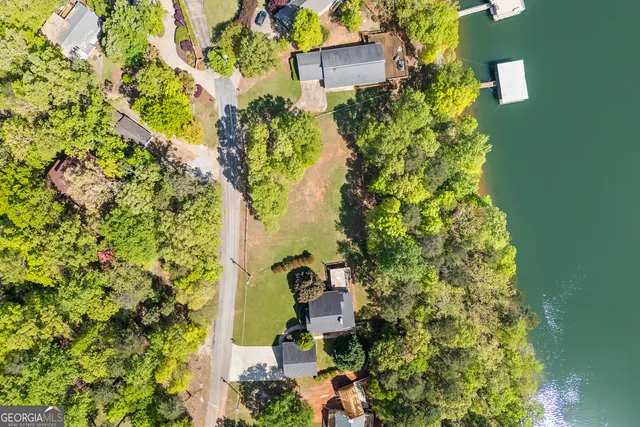an aerial view of a house with a yard and lake view