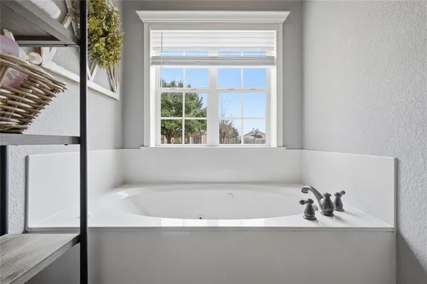 a bathroom with a bathtub and a window