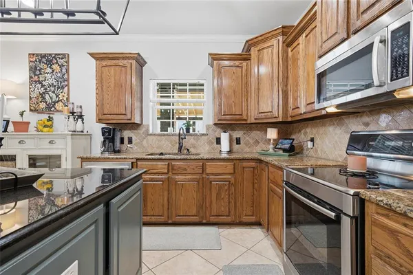 a kitchen with stainless steel appliances granite countertop a sink stove and cabinets