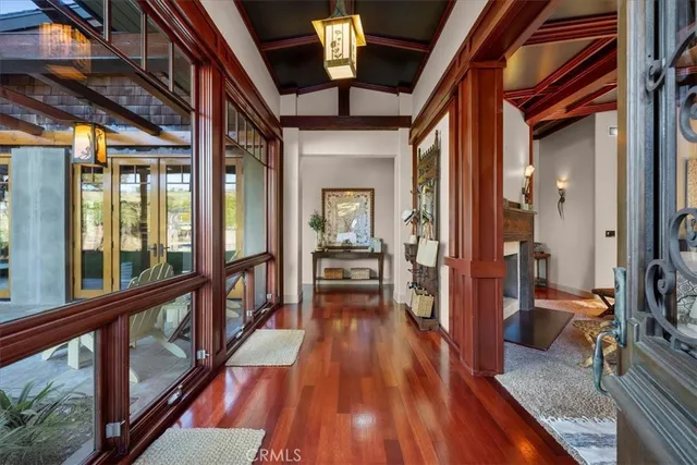 a view of a hallway with wooden floor and furniture