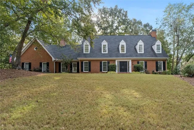 front view of a brick house with potted plants