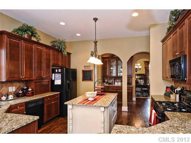 419 Bull Finch Bend Fort Mill, SC 29708 - Photo 6 of 16 a kitchen center island with stainless steel appliances granite countertop a stove top oven a sink and cabinets